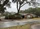 Brick ranch house with a long driveway and mature trees at 5030 Haywood Ruffin Rd, St Cloud, FL 34771