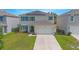 Two-story house with solar panels, driveway and green lawn at 5283 Bracks Landing Dr Dr, St Cloud, FL 34771