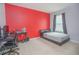 Bright bedroom with a desk and bed, featuring a red accent wall at 5283 Bracks Landing Dr Dr, St Cloud, FL 34771