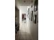 A long hallway with tiled floors and decoratively framed artwork along the wall at 602 Caddy Dr, Kissimmee, FL 34759