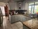 A well-lit kitchen featuring granite countertops, gray cabinets, stainless steel sink and modern appliances at 602 Caddy Dr, Kissimmee, FL 34759