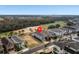 An aerial view of the home and surrounding neighborhood near a golf course and large wooded area at 733 Desert Mountain Ct, Reunion, FL 34747
