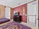 Fun bedroom features two twin beds, an exposed brick wall, and a view into the hallway at 733 Desert Mountain Ct, Reunion, FL 34747