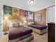 Themed bedroom with two beds, brick accent wall, and themed decor at 733 Desert Mountain Ct, Reunion, FL 34747