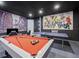 This game room boasts superhero themed wall art, a pool table, and a ping pong table at 733 Desert Mountain Ct, Reunion, FL 34747