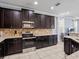 Well-equipped kitchen with dark wood cabinetry and granite countertops at 733 Desert Mountain Ct, Reunion, FL 34747