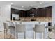 Kitchen bar with dark wood cabinetry, granite countertops, stainless steel appliances, and bar stool seating at 733 Desert Mountain Ct, Reunion, FL 34747