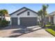 Two-car garage, light gray exterior, and a paved driveway at 1062 Umbria Dr, Kissimmee, FL 34759