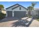 Two-car garage, light gray exterior, and a paved driveway at 1062 Umbria Dr, Kissimmee, FL 34759