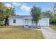 White single-story house with gray roof, attached garage, and well-manicured lawn at 110 Talavera Ln, Kissimmee, FL 34758