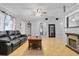 Living room with black leather couch, coffee table, ceiling fan and fireplace at 110 Talavera Ln, Kissimmee, FL 34758