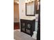 Dark wood bathroom vanity with a large mirror and ample storage at 1296 Skyline Dr, Tavares, FL 32778