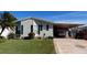 Single-wide manufactured home with carport and landscaped lawn at 1296 Skyline Dr, Tavares, FL 32778