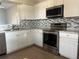 Kitchen features stainless steel appliances and white cabinets at 136 Pinewood Cir, Kissimmee, FL 34743