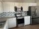 Kitchen features stainless steel appliances and white cabinets at 136 Pinewood Cir, Kissimmee, FL 34743