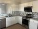 Kitchen features stainless steel appliances and white cabinets at 136 Pinewood Cir, Kissimmee, FL 34743