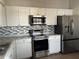 Kitchen features stainless steel appliances and white cabinets at 136 Pinewood Cir, Kissimmee, FL 34743