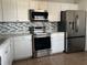 Kitchen features stainless steel appliances and white cabinets at 136 Pinewood Cir, Kissimmee, FL 34743