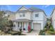 Two-story house with a gray roof, light beige and white siding, and a two-car garage at 1812 Sandy Park Trl, Kissimmee, FL 34747