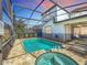 Relaxing screened-in pool and spa with a patio area at 1812 Sandy Park Trl, Kissimmee, FL 34747