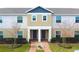 Tan two-story townhome with gray doors and landscaping at 215 Annabelle Way, Davenport, FL 33837