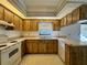Galley kitchen with wood cabinets and white appliances at 219 Macon Way, St Cloud, FL 34769