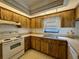 Galley kitchen with wood cabinets and white appliances at 219 Macon Way, St Cloud, FL 34769