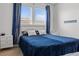 Bright bedroom with blue bedding, a padded headboard, and bright natural light at 2276 Centerra Loop, Kissimmee, FL 34741