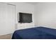 Modern bedroom featuring a TV, closet, and simple navy bedding at 2276 Centerra Loop, Kissimmee, FL 34741