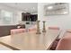 Bright dining area with a modern table, pink chairs, and an open view of the kitchen at 2276 Centerra Loop, Kissimmee, FL 34741