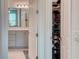 View into a bathroom with gray cabinets, tile floors, and a walk-in closet with clothing and accessories at 2285 Palm Tree Dr, Kissimmee, FL 34759
