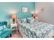 Bedroom with vibrant blue walls, tropical-themed bedding, and matching chair at 2285 Palm Tree Dr, Kissimmee, FL 34759