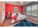 Comfortable bedroom featuring a wooden headboard, bright red accent wall, and ample natural light at 2285 Palm Tree Dr, Kissimmee, FL 34759