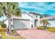 Beautiful exterior elevation with a brick driveway, two-car garage, and well-maintained landscaping at 2285 Palm Tree Dr, Kissimmee, FL 34759