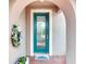 Inviting arched entrance with a teal front door featuring decorative glass and a 'Welcome' mat at 2285 Palm Tree Dr, Kissimmee, FL 34759