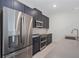 Stainless steel appliances and dark blue cabinetry in kitchen at 2381 Reading Trl, Kissimmee, FL 34746