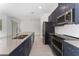 Modern kitchen with stainless steel appliances and dark blue cabinets at 2381 Reading Trl, Kissimmee, FL 34746