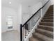 Modern staircase with black metal railing and carpeted steps at 2381 Reading Trl, Kissimmee, FL 34746