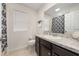 Well-lit bathroom with a large mirror, a vanity with dark cabinets, and neutral colored tile at 2449 Varenna Loop, Kissimmee, FL 34741