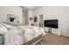 Bright bedroom with a large bed, TV on a modern bedside table, and a decorative mirror at 2449 Varenna Loop, Kissimmee, FL 34741