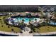 Aerial view of a luxurious community pool area with palm trees, lounge chairs, and a splash pad at 2449 Varenna Loop, Kissimmee, FL 34741