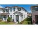 Charming townhouse featuring a covered entryway, well-maintained lawn, and elegant architectural details at 2449 Varenna Loop, Kissimmee, FL 34741