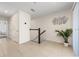 Well-lit hallway with tile flooring, decorative wall art, a staircase, and indoor plant at 2449 Varenna Loop, Kissimmee, FL 34741