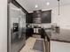 Contemporary kitchen with stainless steel refrigerator, dark cabinets, and an island with granite countertops at 2449 Varenna Loop, Kissimmee, FL 34741
