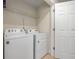 Laundry room featuring a white washer and dryer, a wire shelf, and a white door at 2449 Varenna Loop, Kissimmee, FL 34741