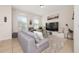 Comfortable living room with a gray sofa, a TV, and decor, creating an inviting atmosphere at 2449 Varenna Loop, Kissimmee, FL 34741