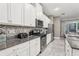 Modern kitchen with white cabinets, granite countertops and stainless steel appliances at 2451 Datura Loop, St Cloud, FL 34772