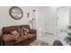 Relaxing sitting room with brown couch and access to laundry room at 2451 Datura Loop, St Cloud, FL 34772