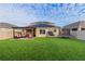 Spacious backyard with green turf, covered patio with comfortable seating, hammock, basketball hoop, and trampoline at 2778 Sunkissed Dr, St Cloud, FL 34771