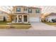 Inviting two-story home featuring a two-car garage, manicured lawn, and charming covered front porch with stylish columns at 2778 Sunkissed Dr, St Cloud, FL 34771